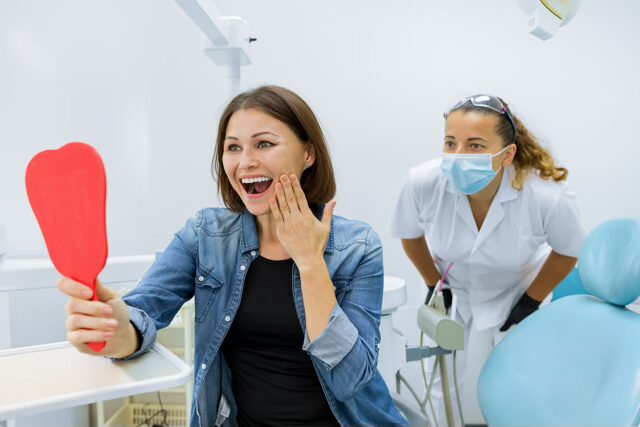 Women at the dentist happy with her new smile